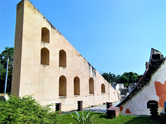 beige concrete building near green trees during daytime in Jantar Mantar India