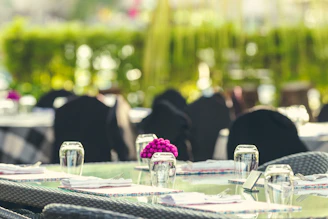 A beautifully arranged outdoor catering setup with yellow and black accents on a sunny terrace.