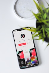 iphone xs on white table showing tiktok app