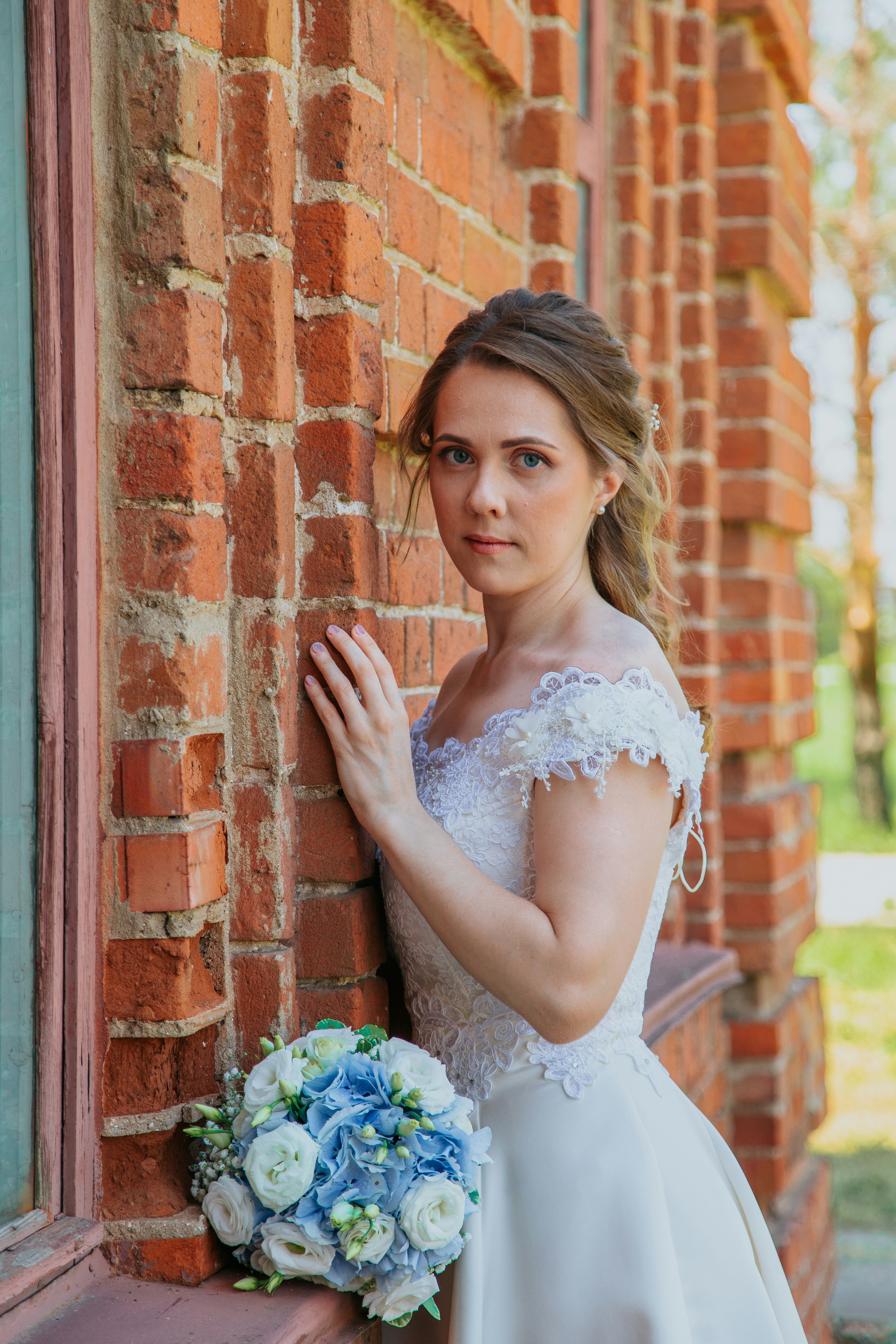Woman in white floral dress leaning on brown brick wall photo – Free ...