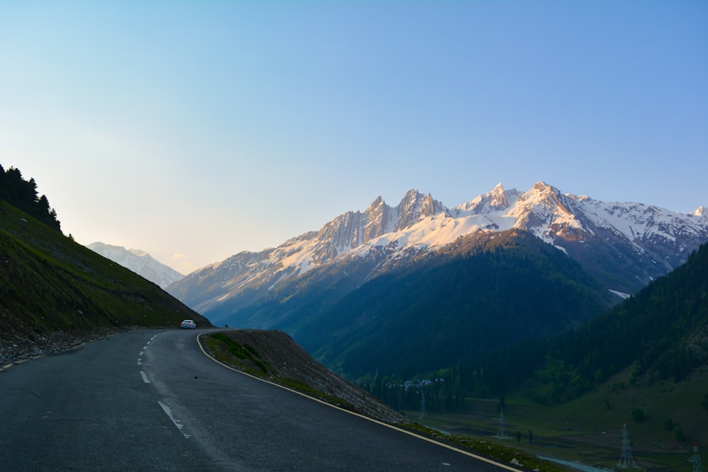 gray asphalt road near green mountains during daytime