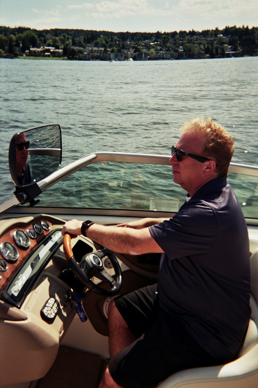 man in black shirt riding on white and red motor boat during daytime