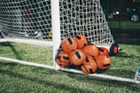 orange soccer ball on green grass field during daytime