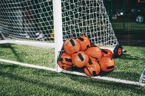 orange soccer ball on green grass field during daytime