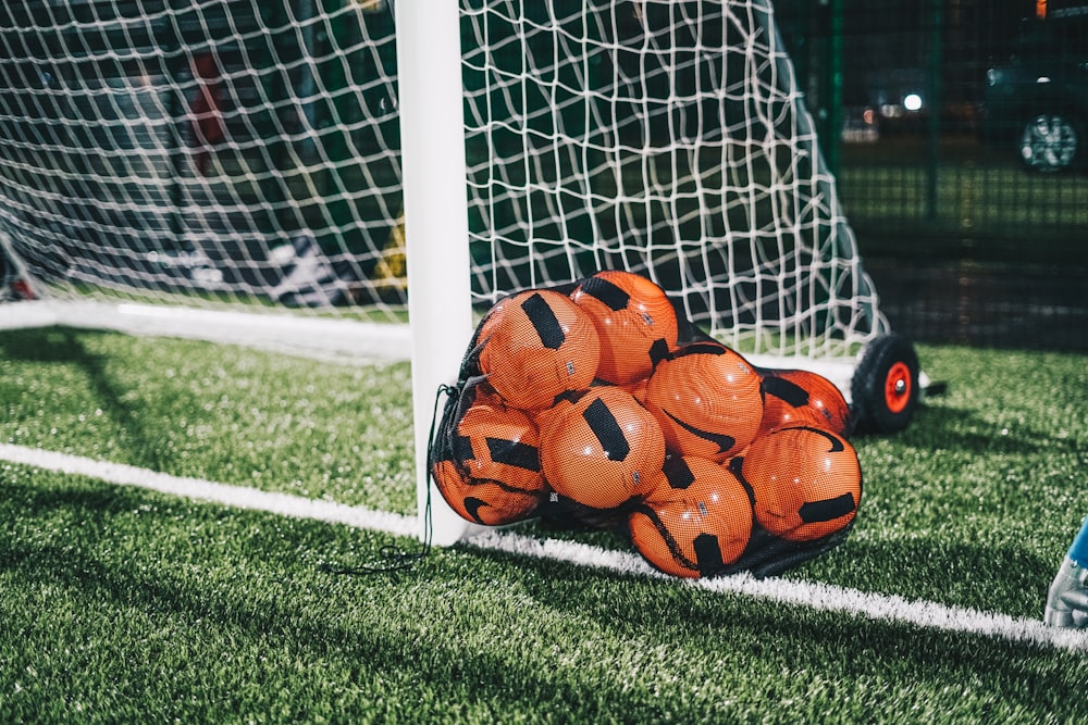 Balón de fútbol naranja en el campo de hierba verde durante el día