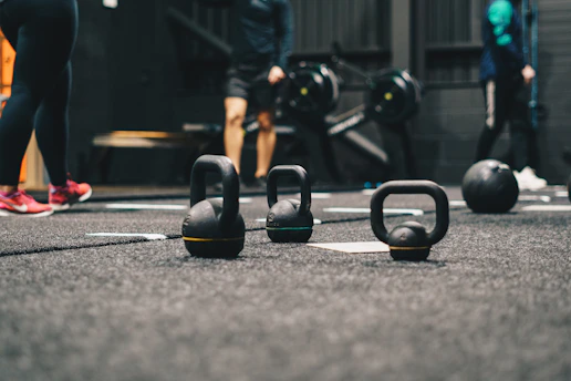 Energetic group doing high-intensity interval training with kettlebells in a gym