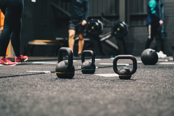 Group of members warming up together with kettlebells on the gym floor