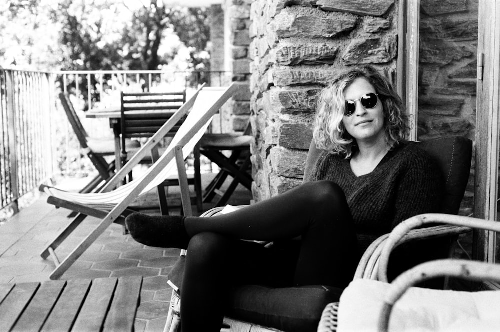 woman in black tank top and black pants sitting on wooden chair