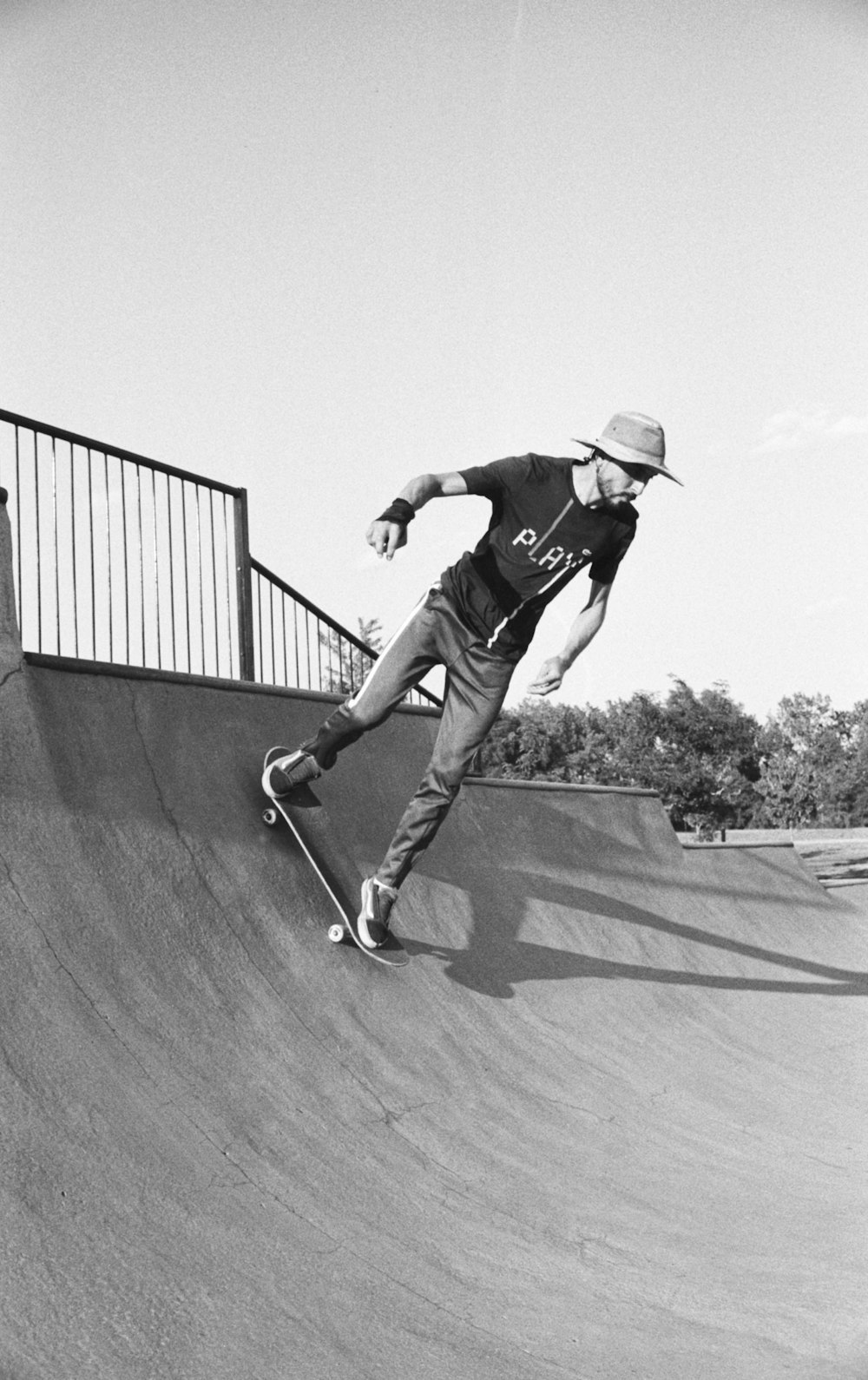 man in black t-shirt and pants riding skateboard in grayscale photography