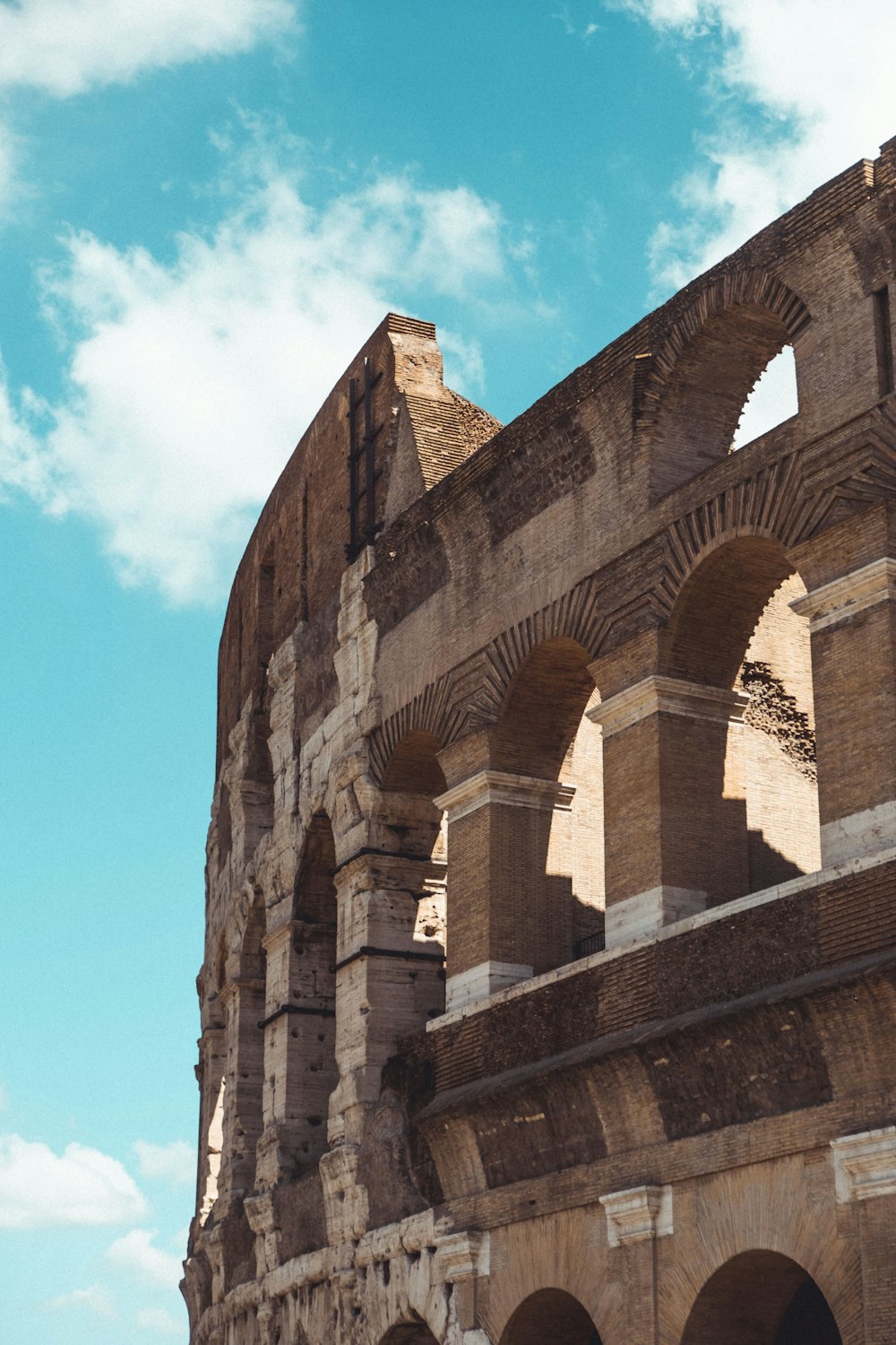 a large stone building with arches and a sky background