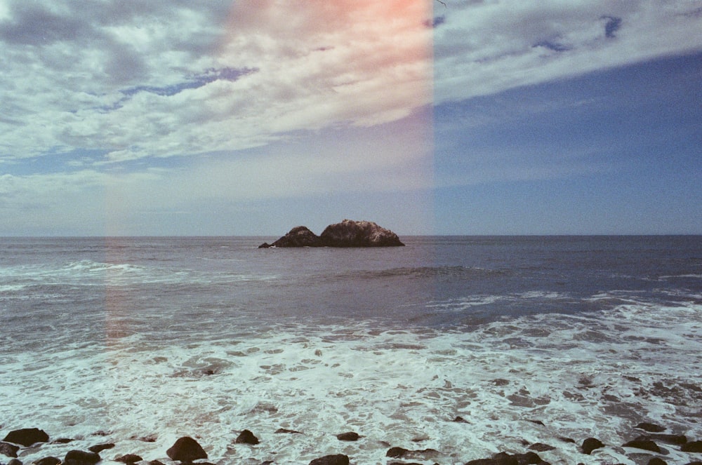 brown rock formation on sea under blue sky during daytime