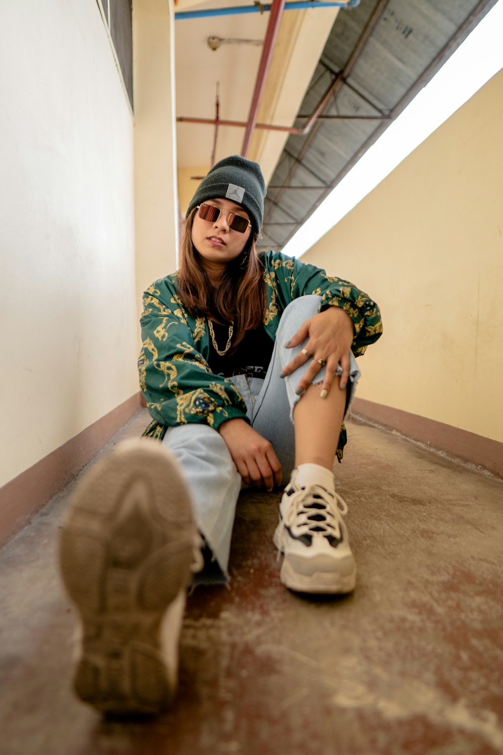 a woman sitting on the floor next to a pair of shoes