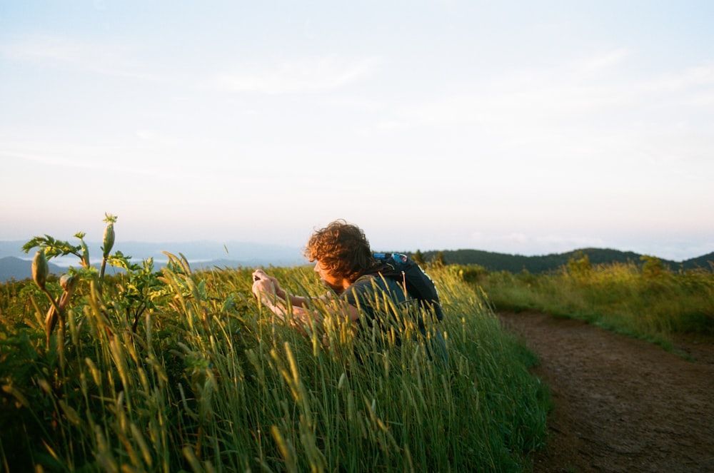 woman in black jacket standing on brown dirt road during daytime