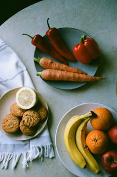 orange and banana fruits on white ceramic plate