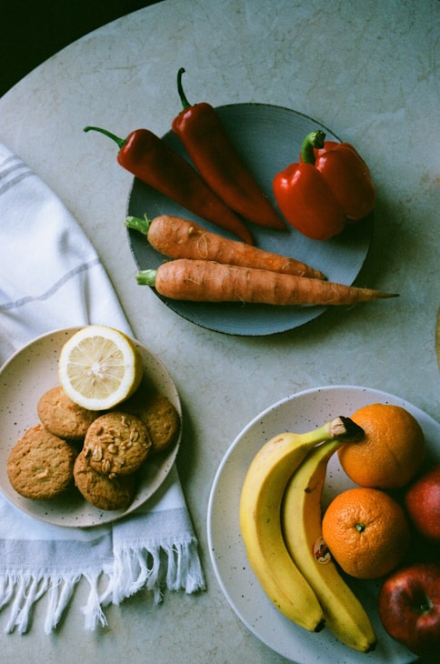 orange and banana fruits on white ceramic plate