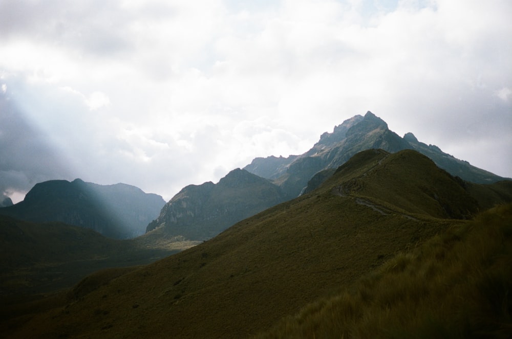 green and brown mountains under white clouds during daytime