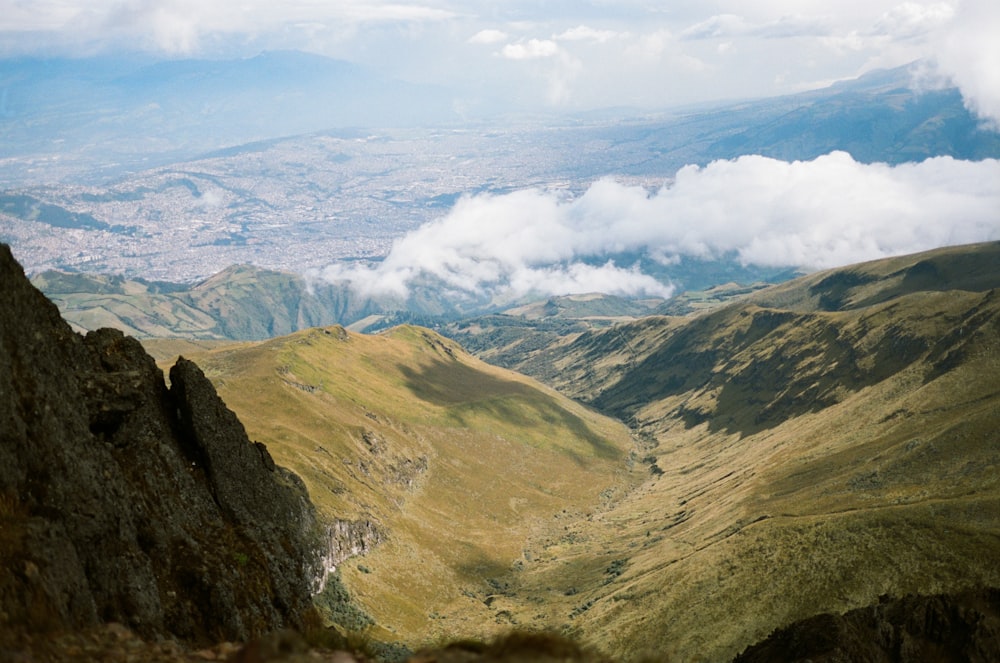 montañas verdes y marrones bajo nubes blancas durante el día