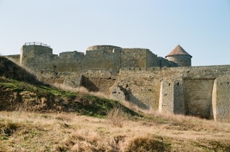 Visitors exploring an ancient Kazakh fortress against a clear blue sky.