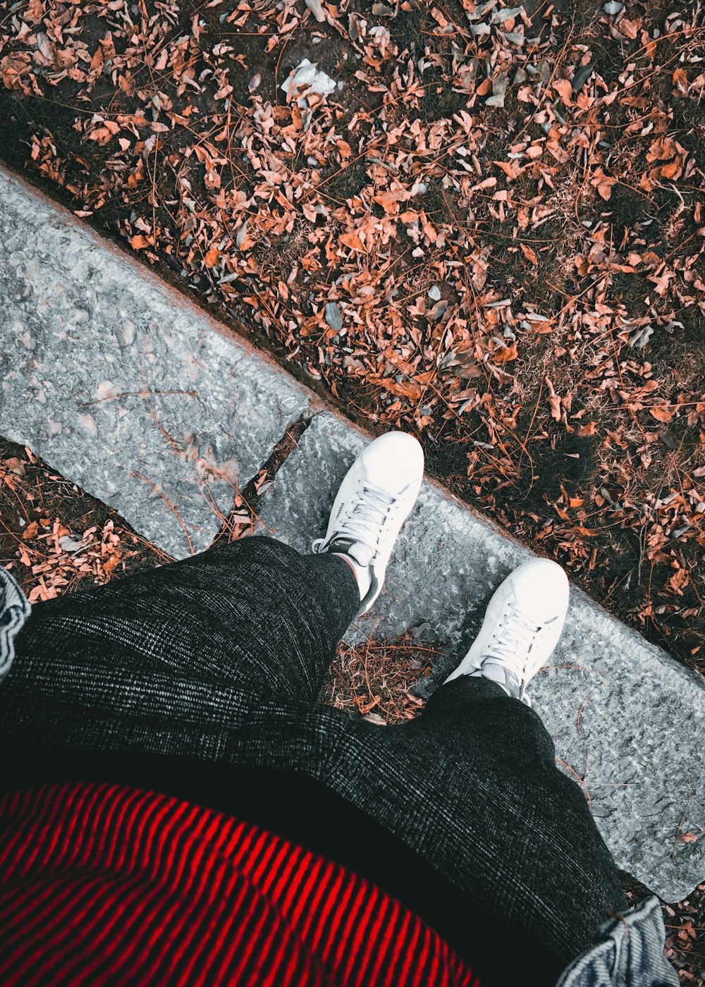 person in black pants and white sneakers