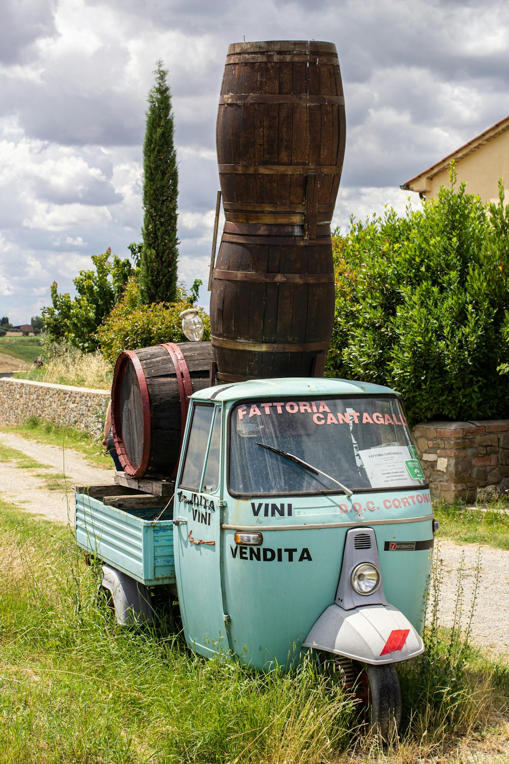 green volkswagen beetle parked beside brown wooden post