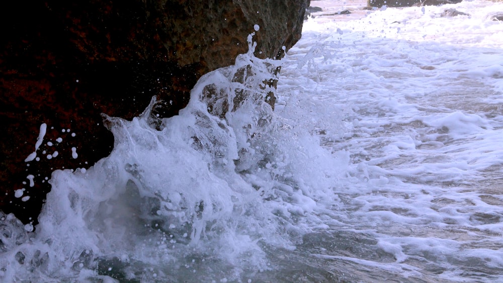 water waves hitting rocky shore during daytime