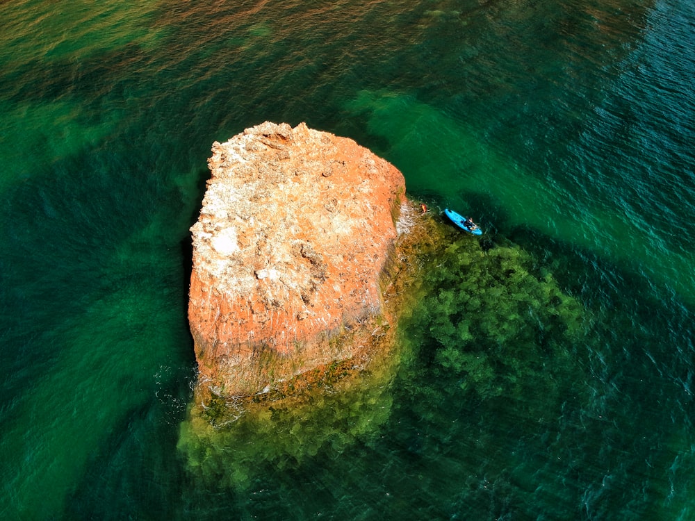 brown rock formation on body of water during daytime