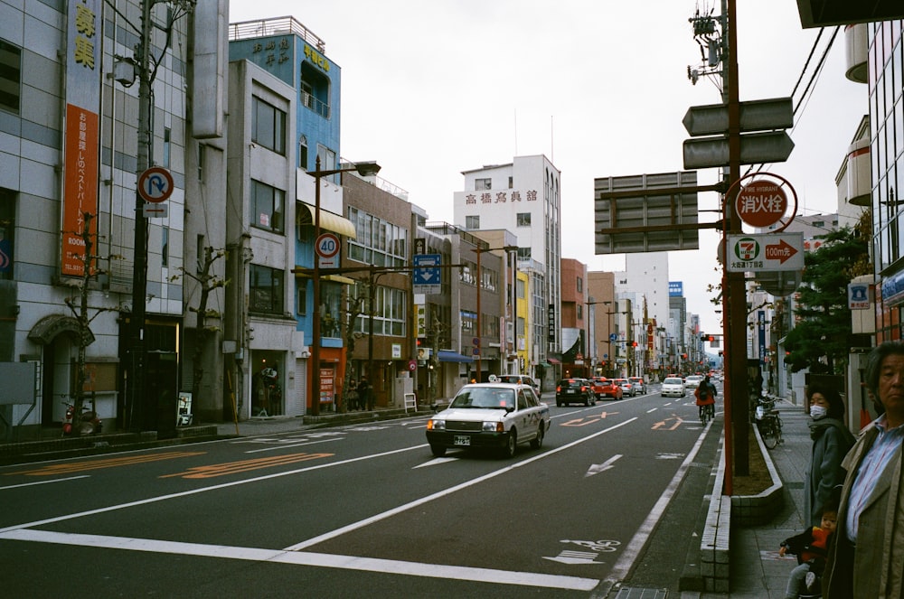 cars on road between buildings during daytime