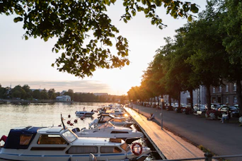 a bunch of boats are parked along the water