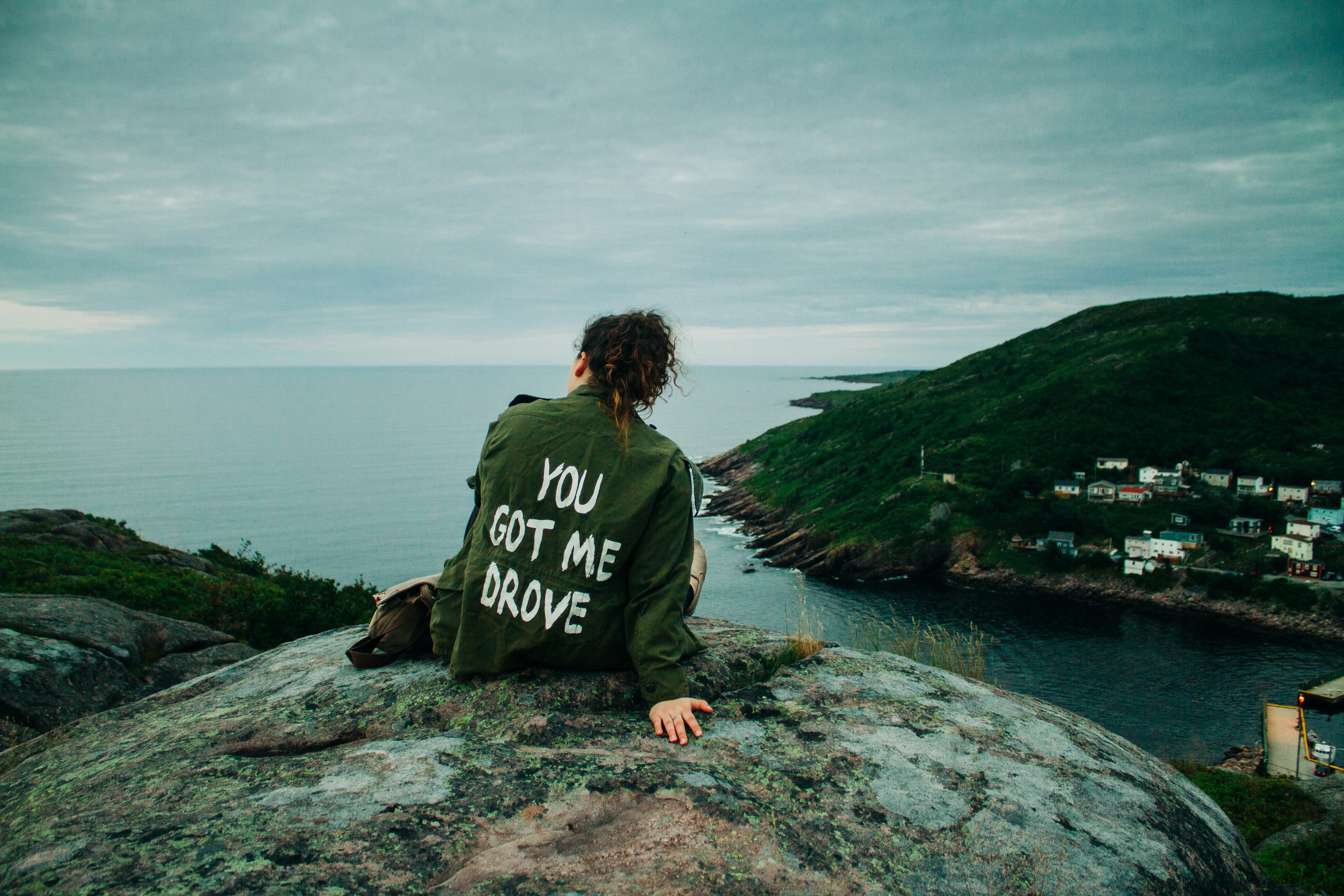 Woman in gray and black long sleeve shirt sitting on gray rock near ...