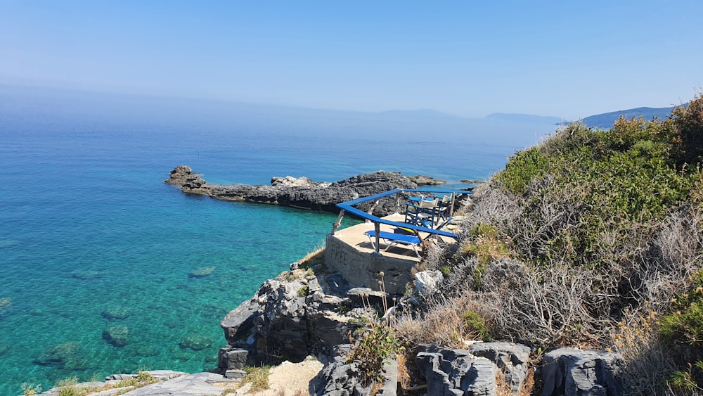 blue and white house on cliff by the sea during daytime