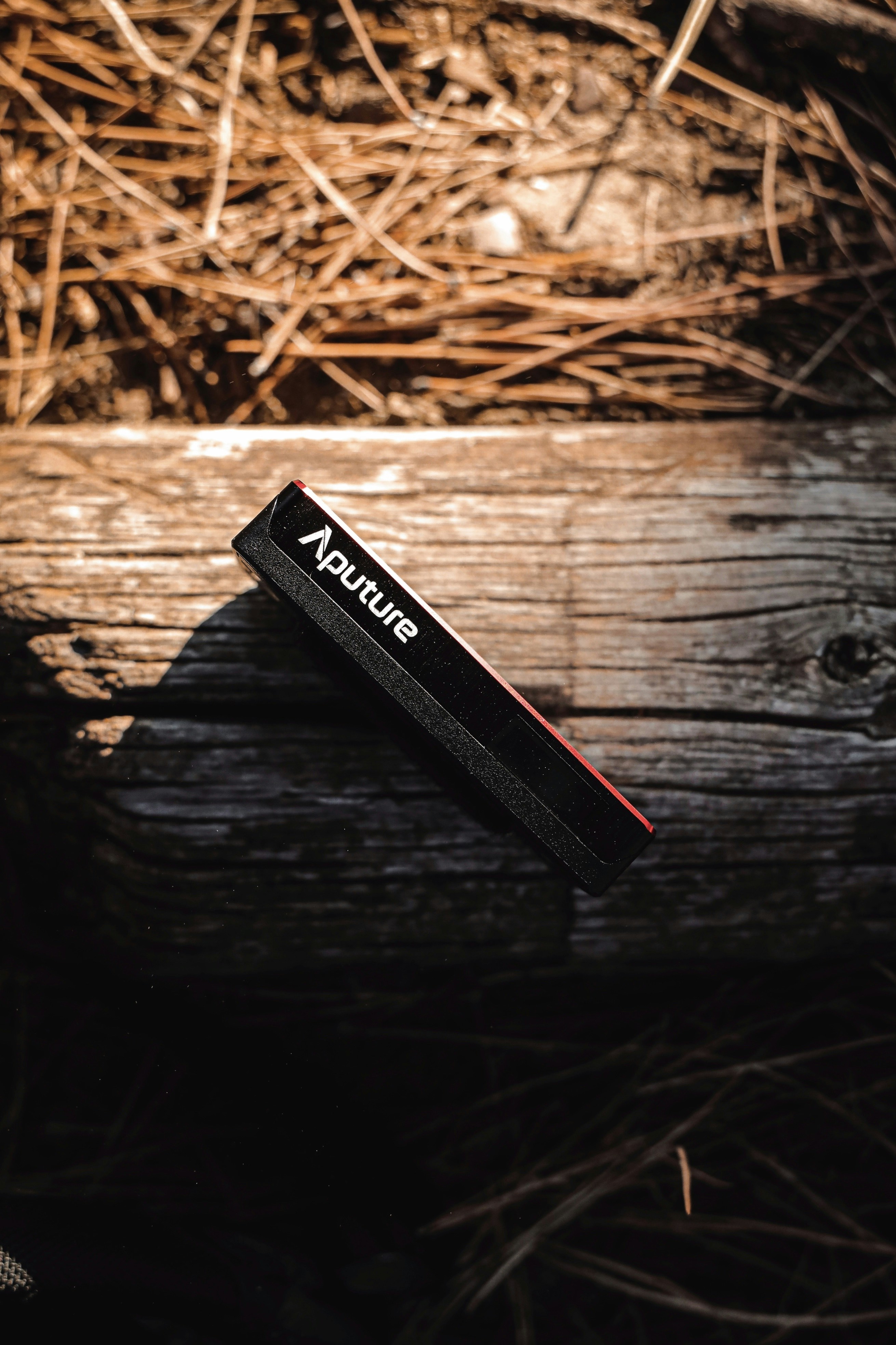 Caja negra y roja sobre superficie de madera marrón