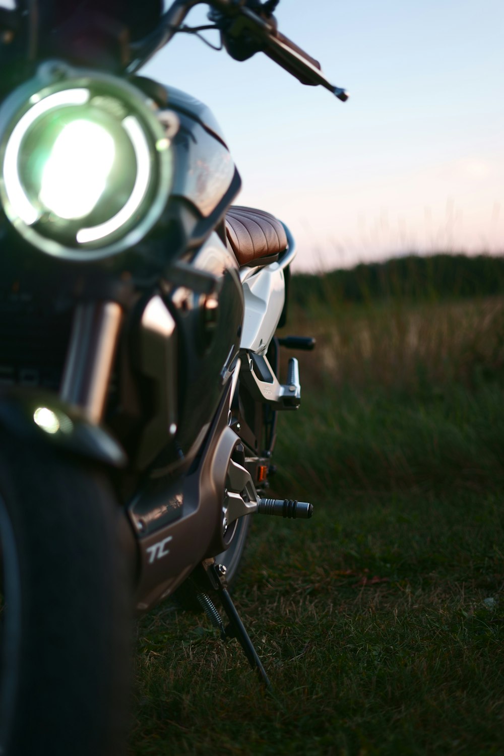 black motorcycle on green grass field during daytime