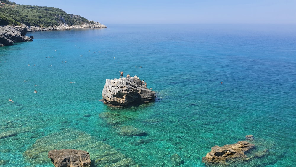 white and black rock formation on body of water during daytime