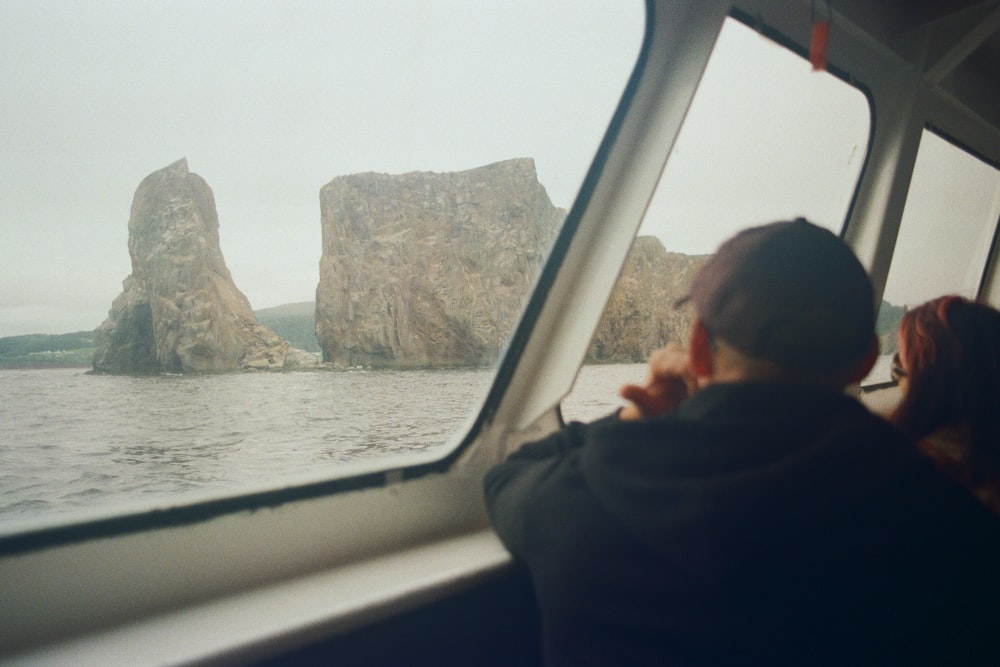 man in black hoodie looking at the sea during daytime