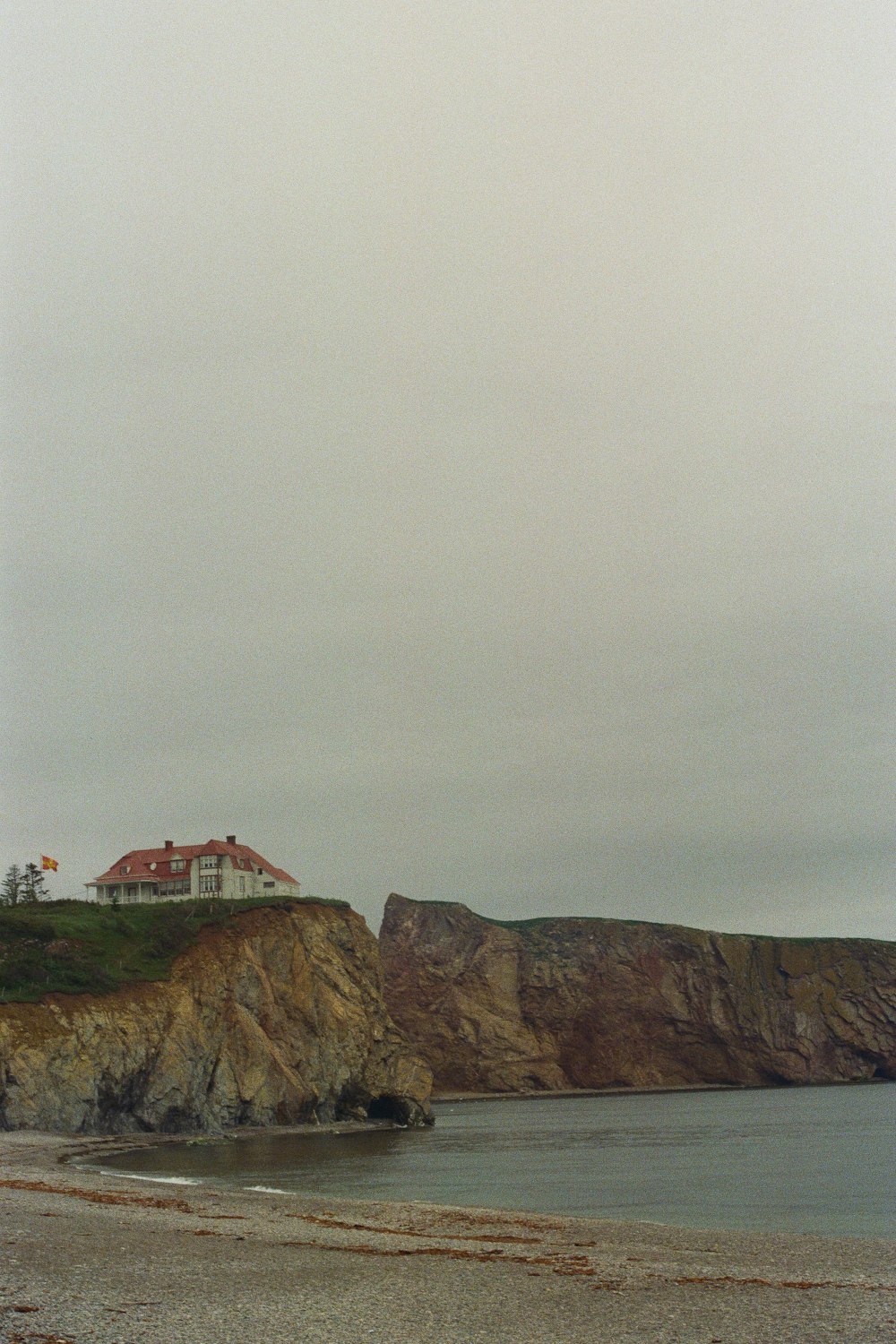 white and brown house on brown rock formation under white sky during daytime