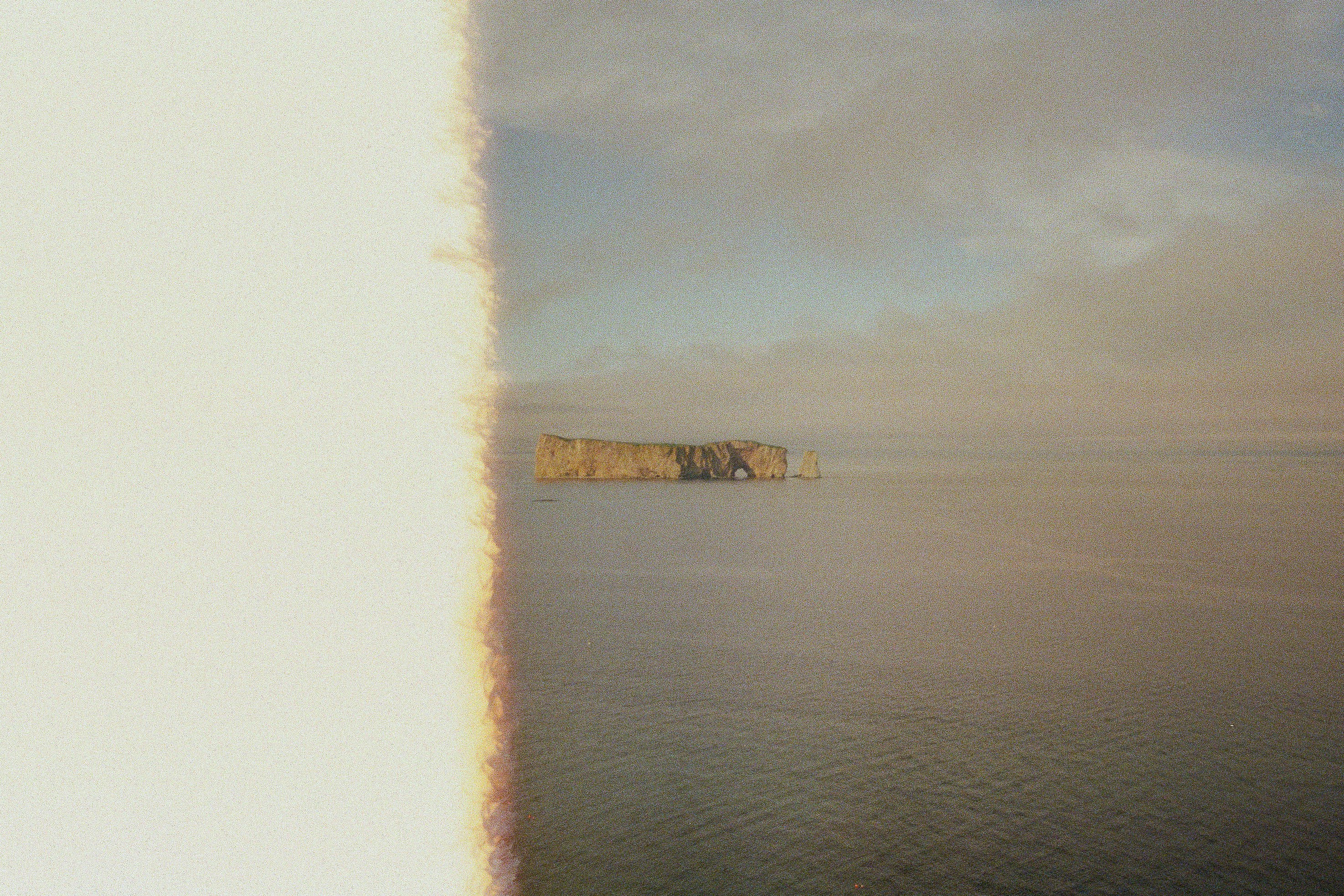 brown concrete building on body of water under white clouds during daytime
