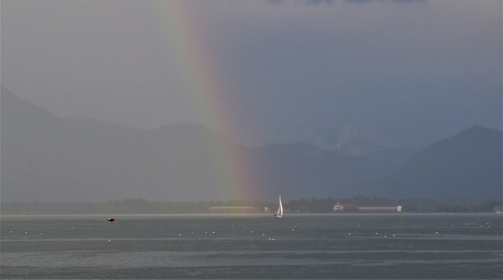 white sail boat on sea during foggy weather