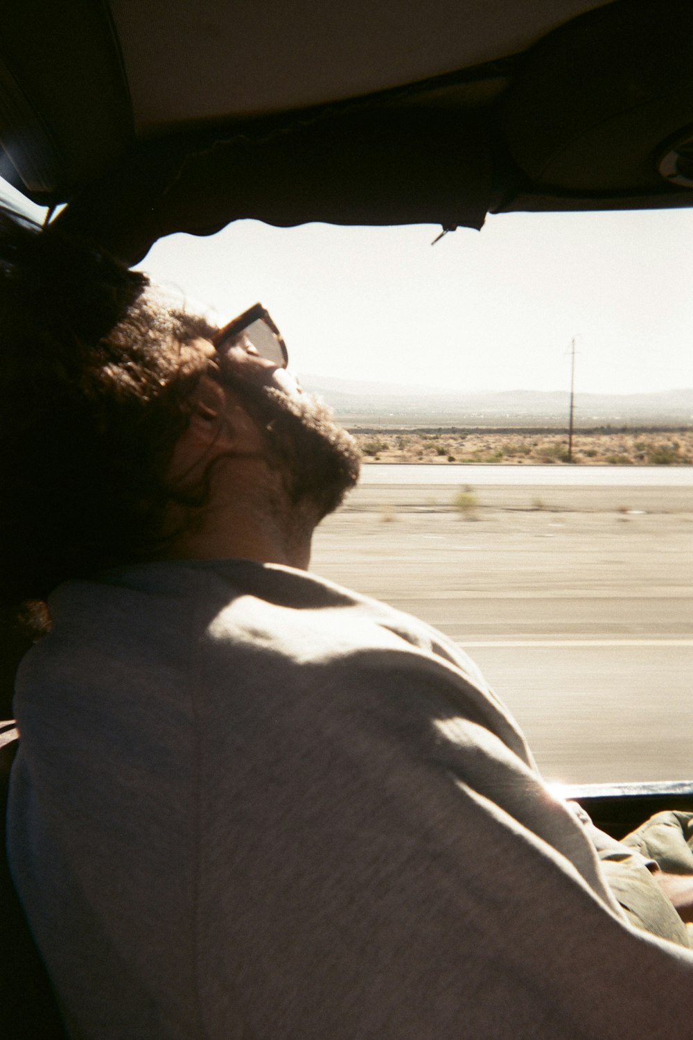 man in gray shirt driving car during daytime