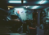 Wide shot of the a1garage workshop with cars lifted and tools scattered, under moody lighting.
