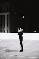 Nighttime stakeout outside a residential building with a detective using binoculars.
