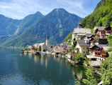 houses near body of water and mountain during daytime