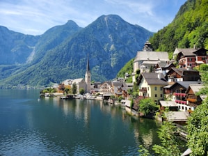houses near body of water and mountain during daytime