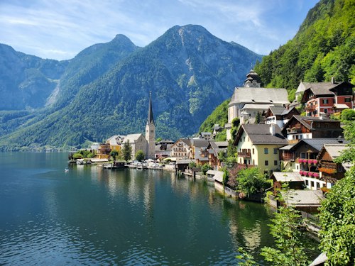 Hallstatt's lakeside village with its church spire reflected in Lake Hallstatt, mountains rising behind