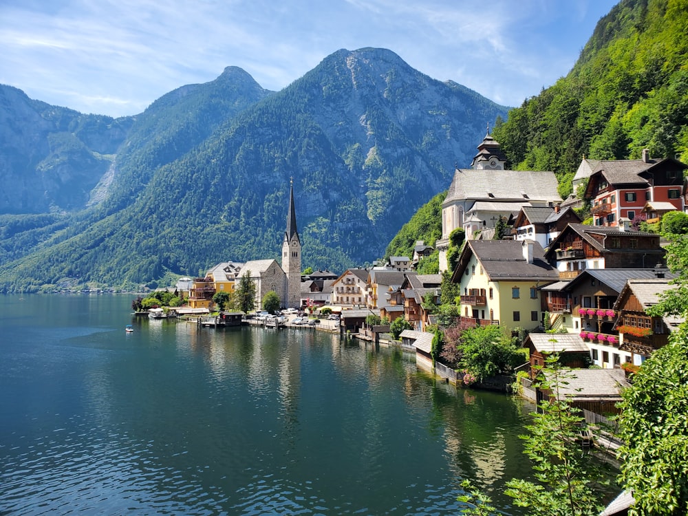 Maisons près d’un plan d’eau et d’une montagne pendant la journée