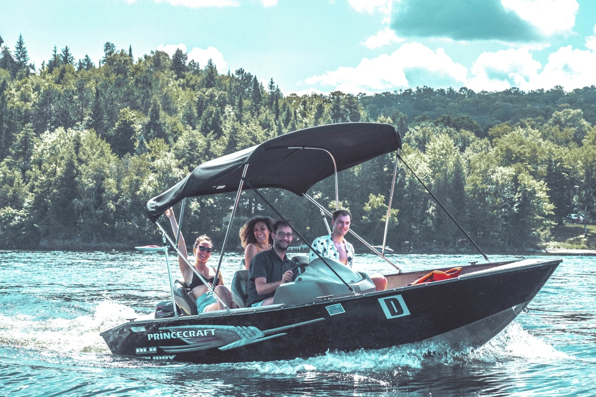 A family takes a boat ride in a Princecraft aluminum boat on a lake with a forest in the background.