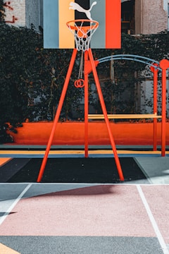 A freshly constructed urban basketball court with vibrant markings and surrounding greenery.