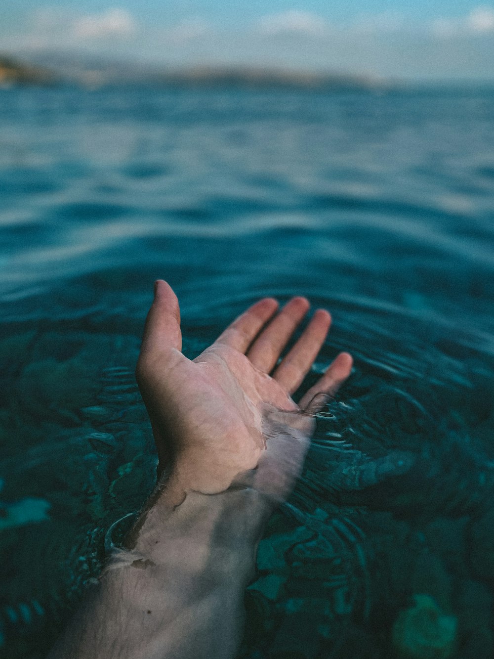 persons left hand on body of water