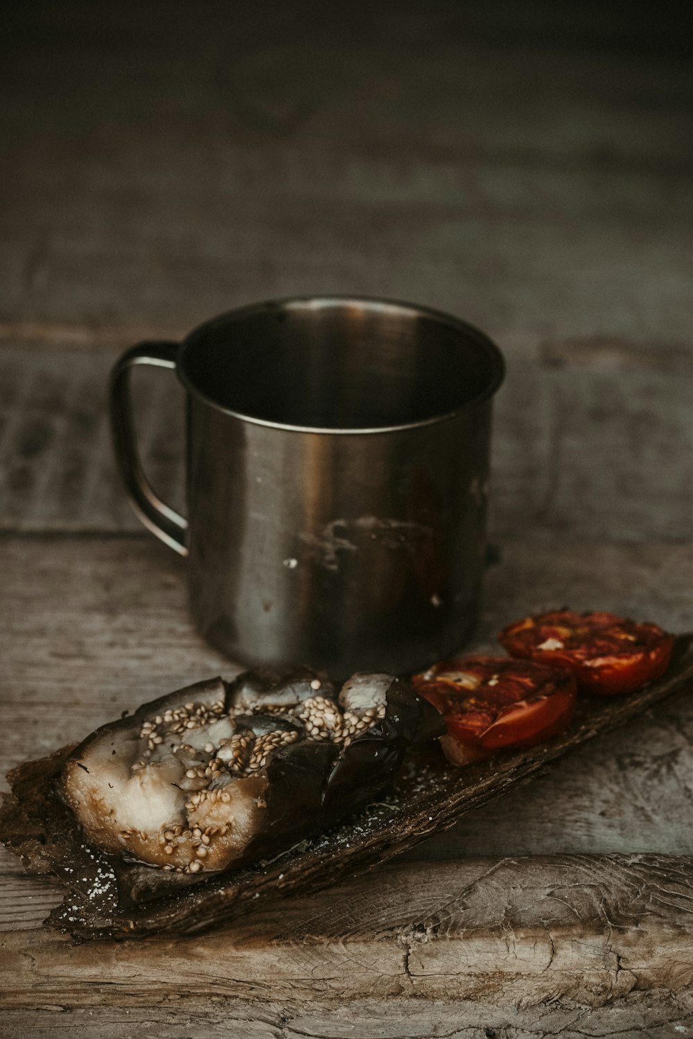 stainless steel mug beside sliced pizza