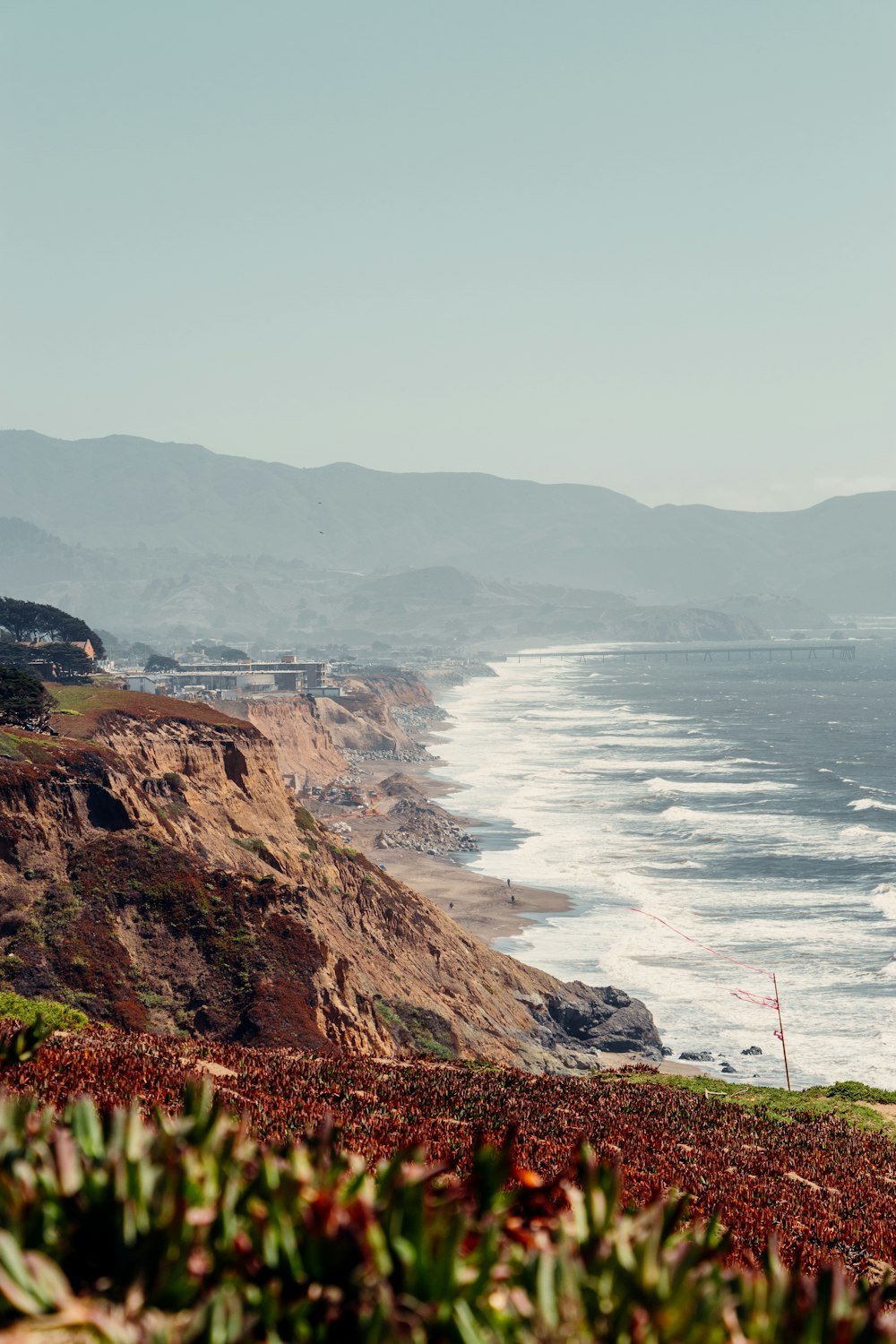 person standing on cliff near body of water during daytime