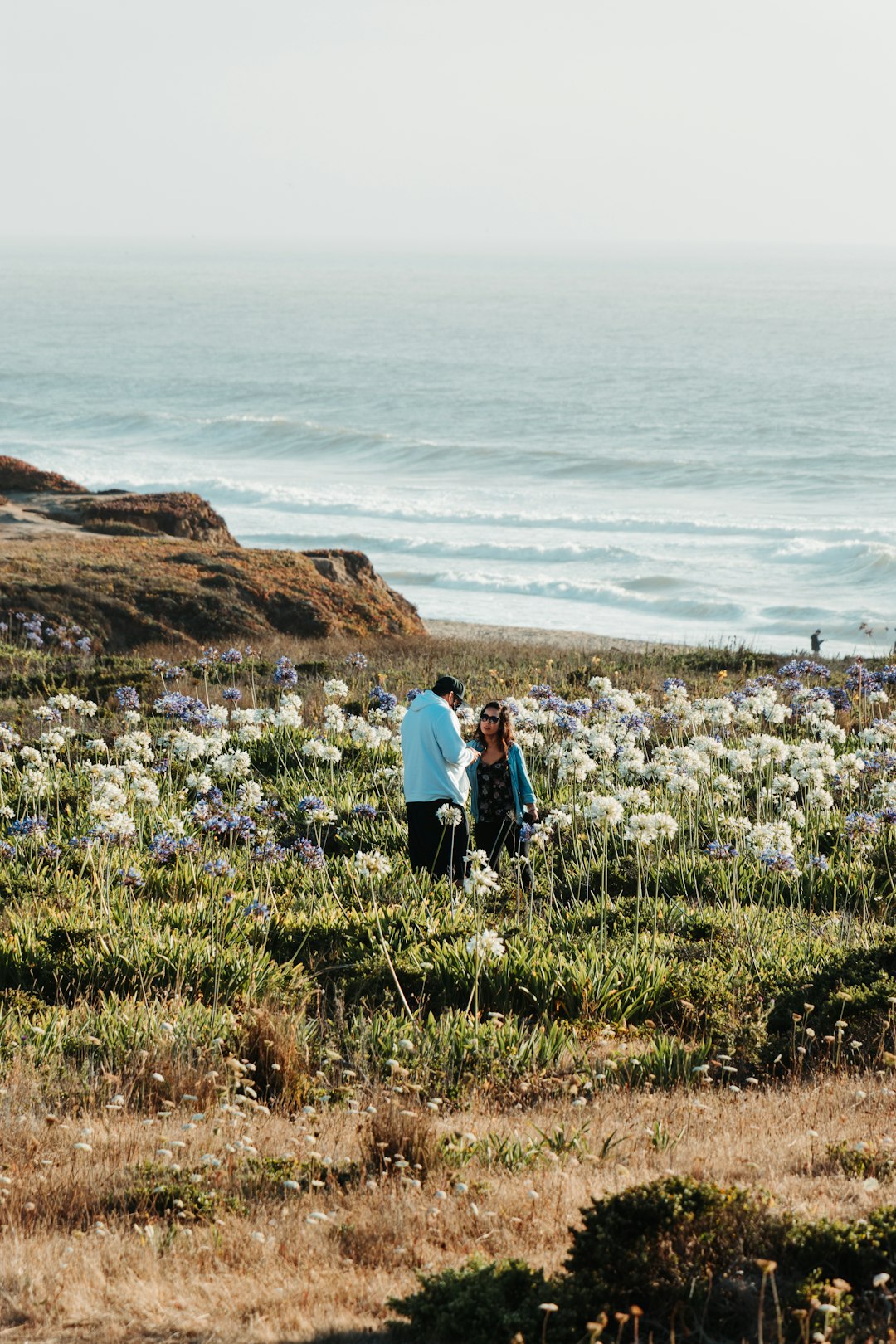 man and woman walking on green grass field during daytime